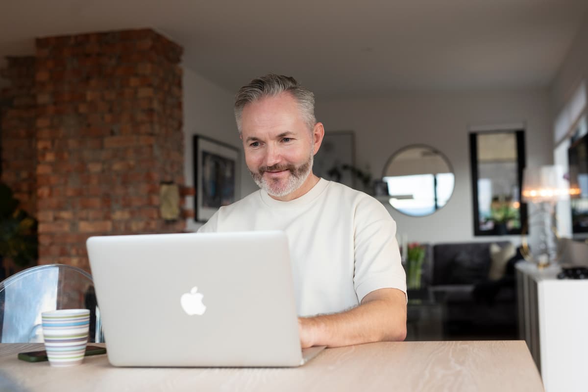 Mann som arbeider Hjemmekontor Mann sitter foran en datamaskin