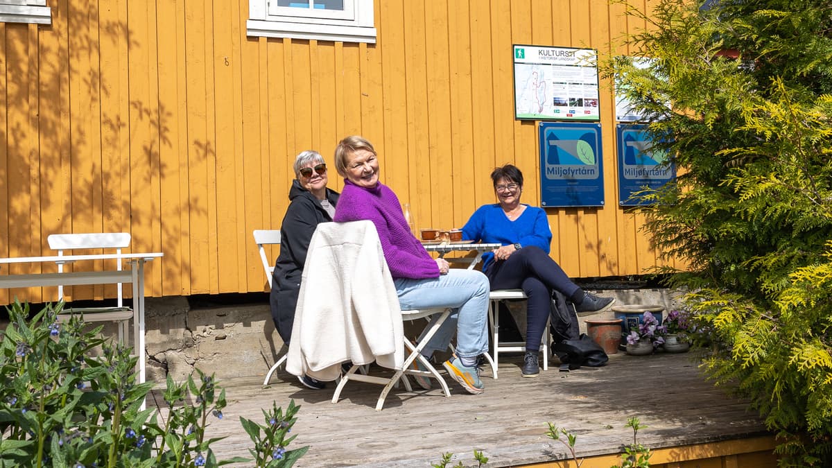 Gulburet damer 1 Tre smilende damer sitter ved et bord