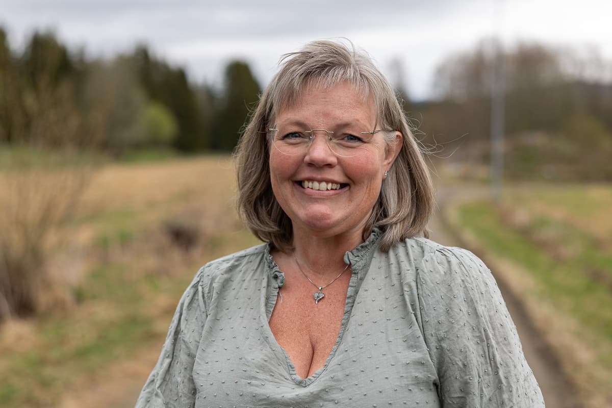 Ann Kristin Brønstad Smilende kvinne på en skogsvei