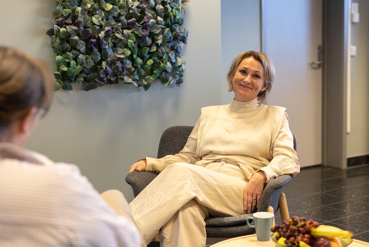Vibeke Tronstad Selnes NTE Smilende dame i samtale med en dame vi ser ryggen til