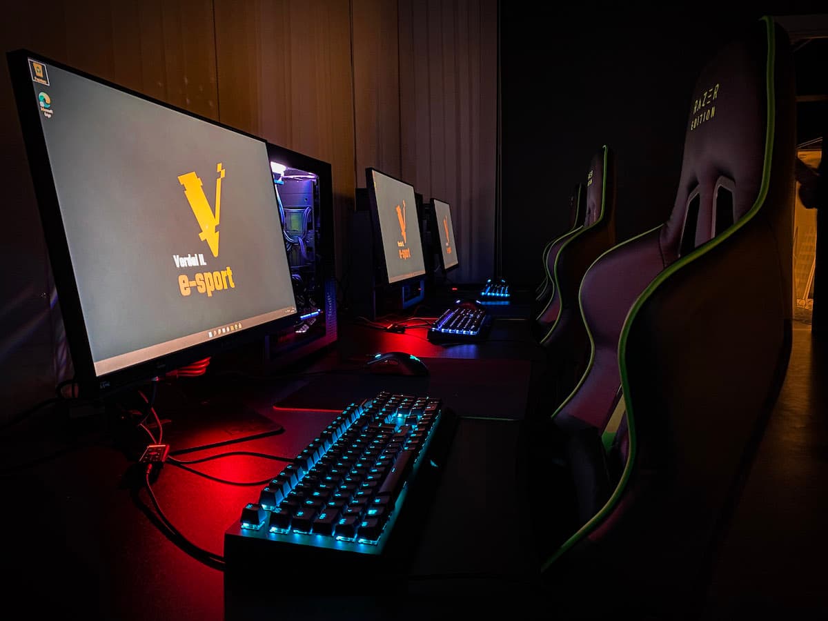 esportutstyr Gaming-pcer med tastatur står på et bord med gamingstoler bak