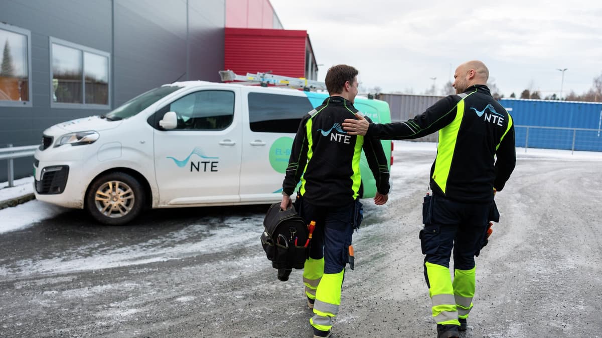 to elektrikere som går mot bilen sin to elektrikere som går mot bilen sin