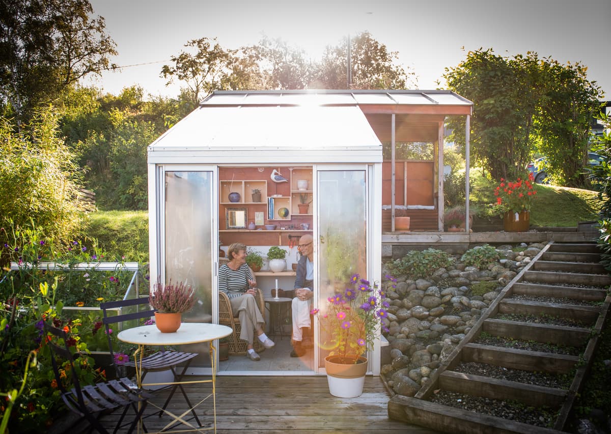 dragland i drivhuset Kvinne og mann drikker kaffe i drivhuset