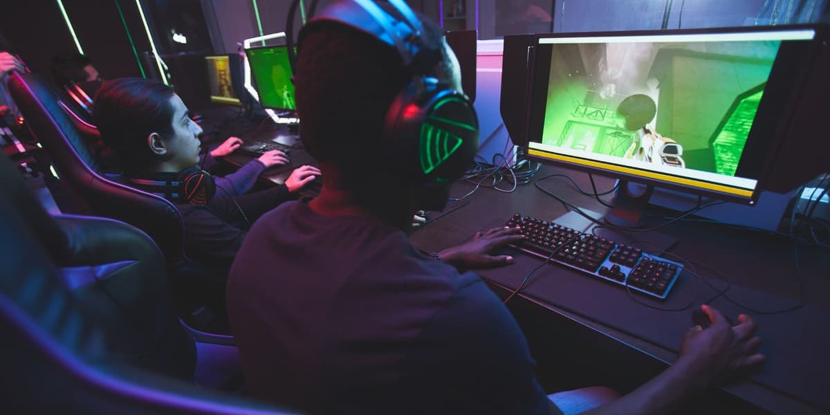 10 videospillsjangre Tre gamere med hodetelefoner foran hver sin PC