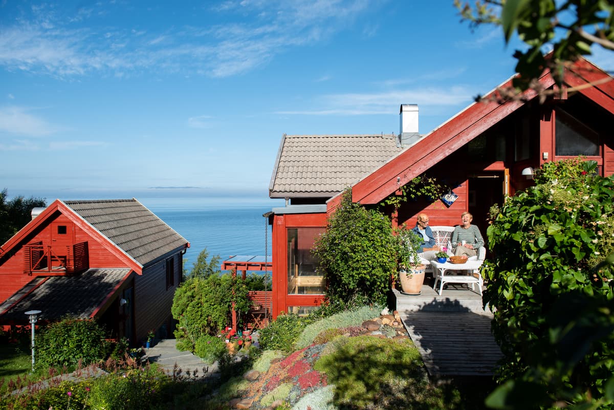dragland på terrassen Mann og kvinne sitter på terassen til et hus med fjordutsikt