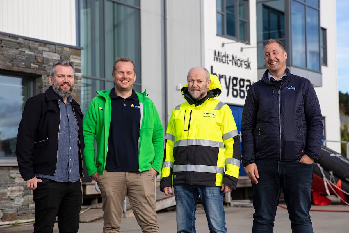 menn på brygga Fire smilende menn på ei brygge